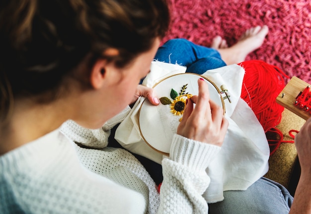 osoba haftująca przy oknie
